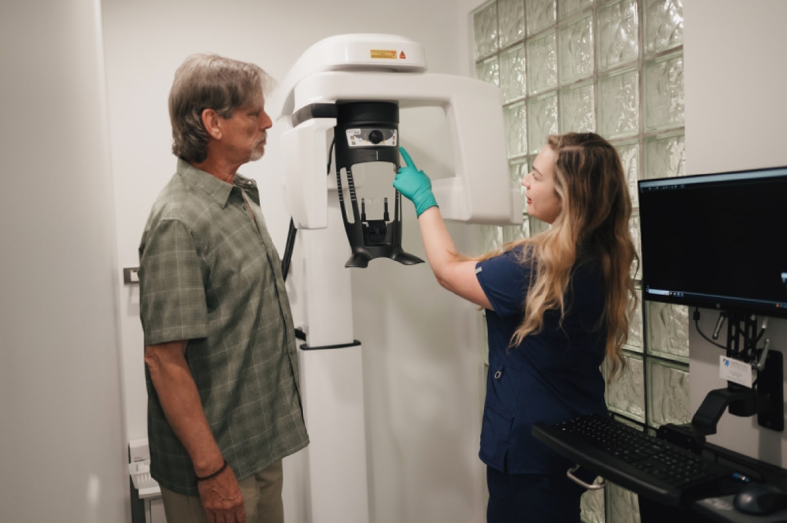 Dental professional examining patient's jaw structure and bone volume with hands-on assessment
