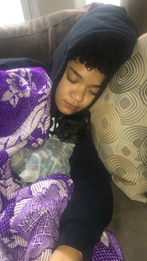 A photo of Cass Hebert taking a nap with her dog, Oscar.