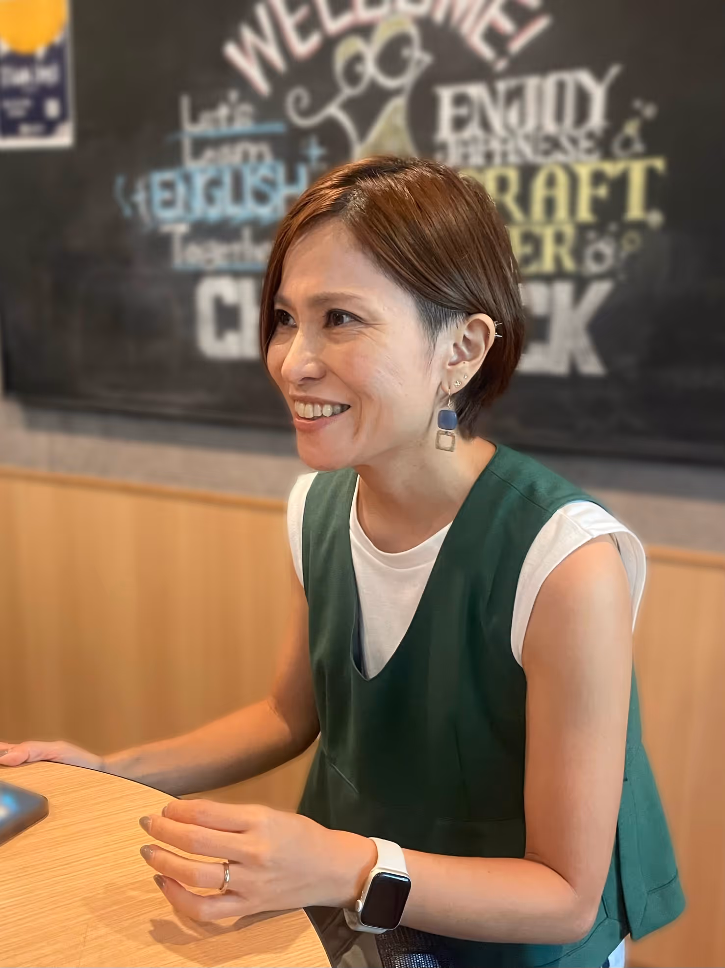 A person sitting at a table, smiling.