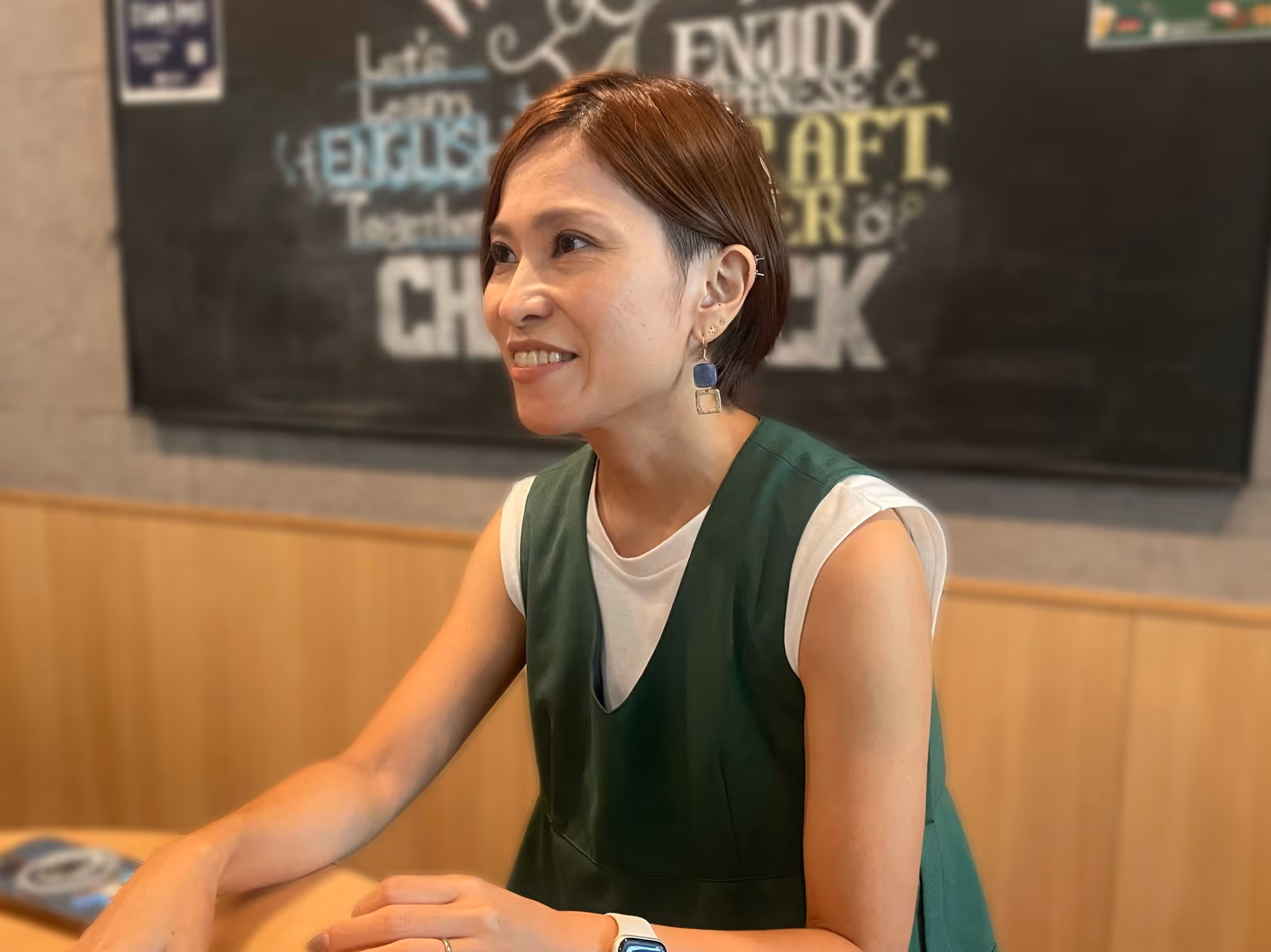 A person sitting at a table, smiling.