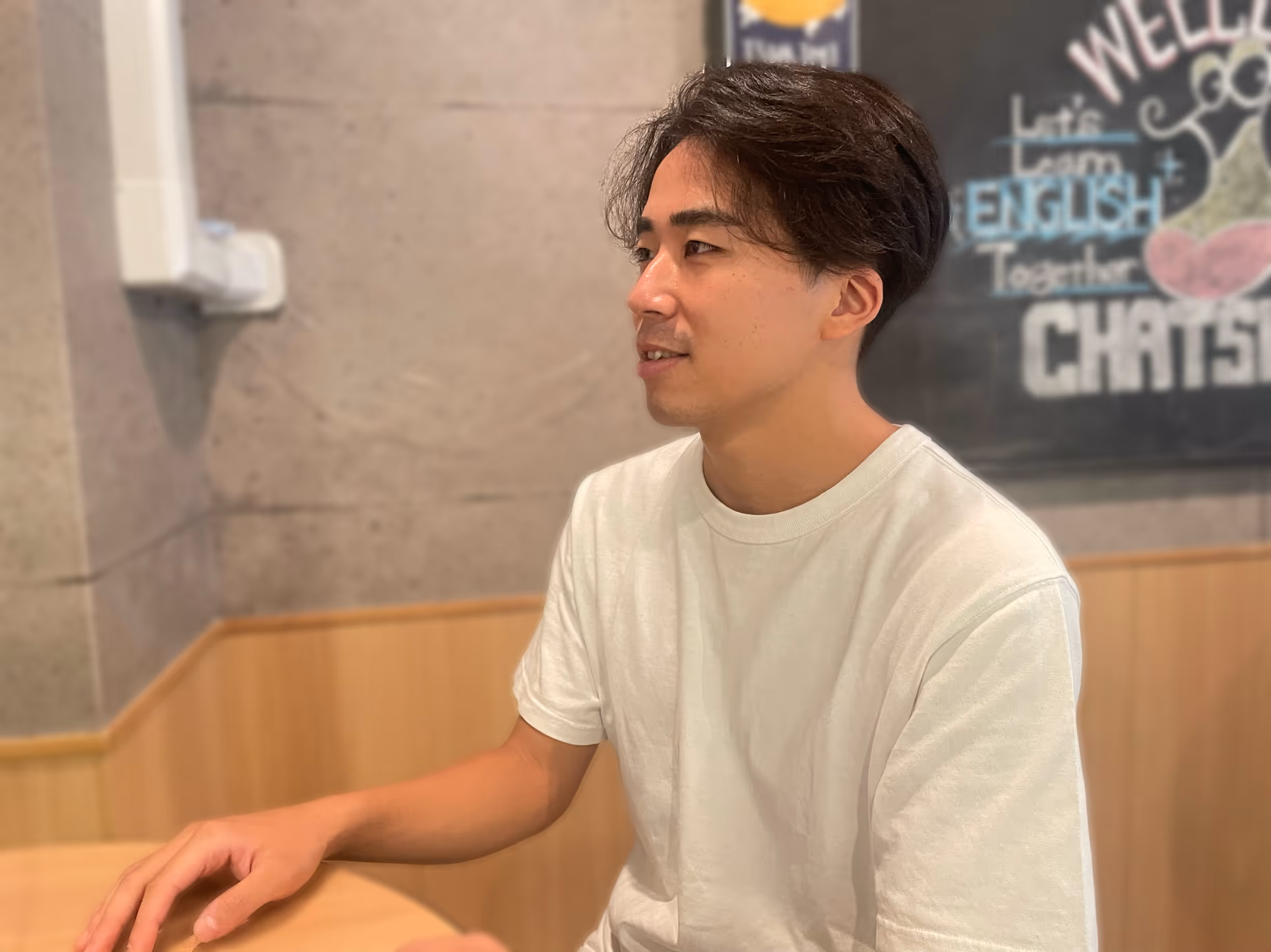 A person sitting at a table, smiling.