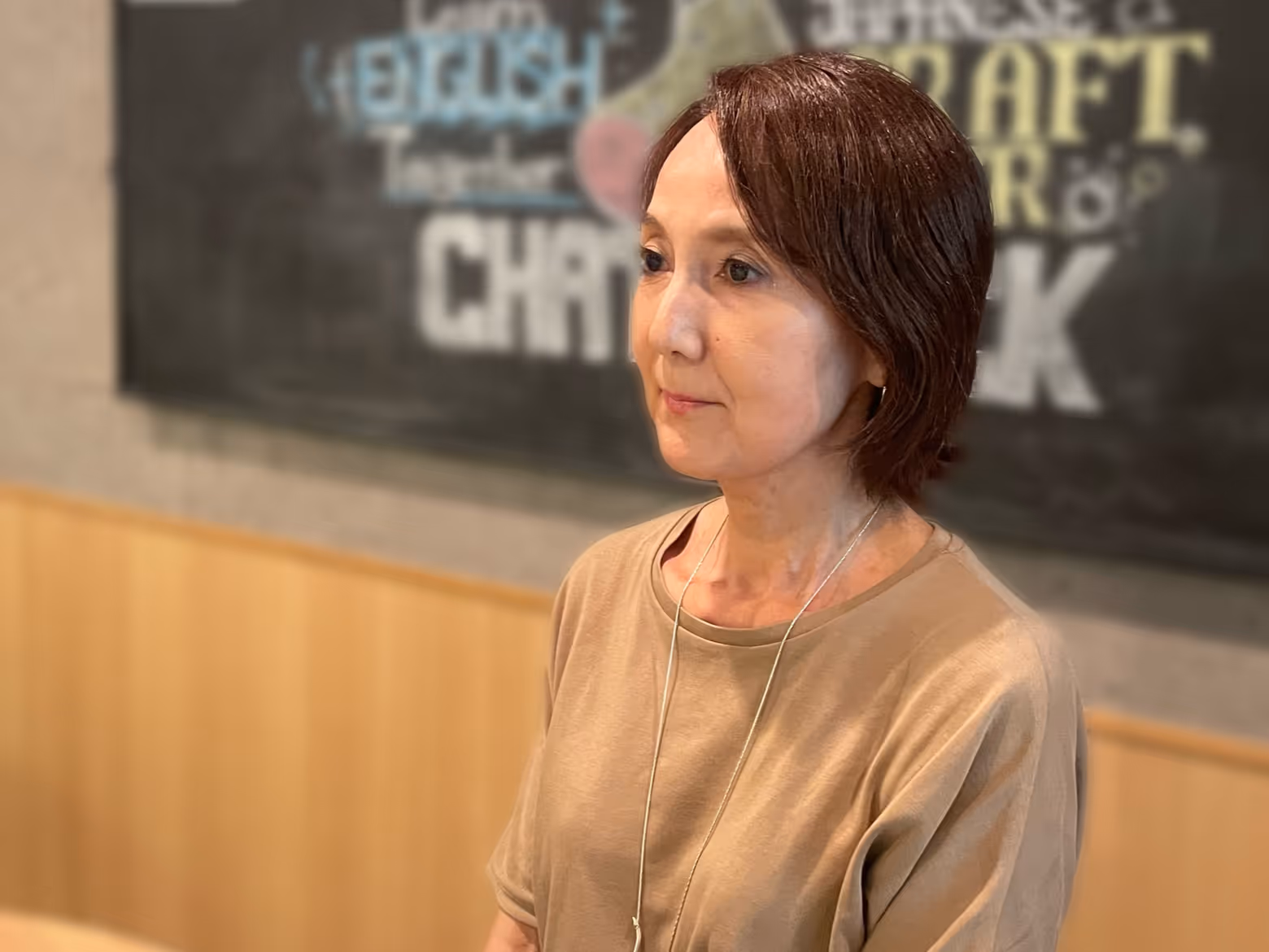 A person sitting at a table, smiling.