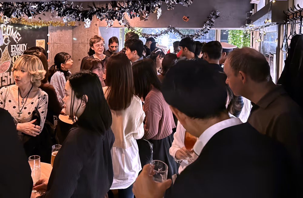 A crowd of people at night inside of a small event venue.