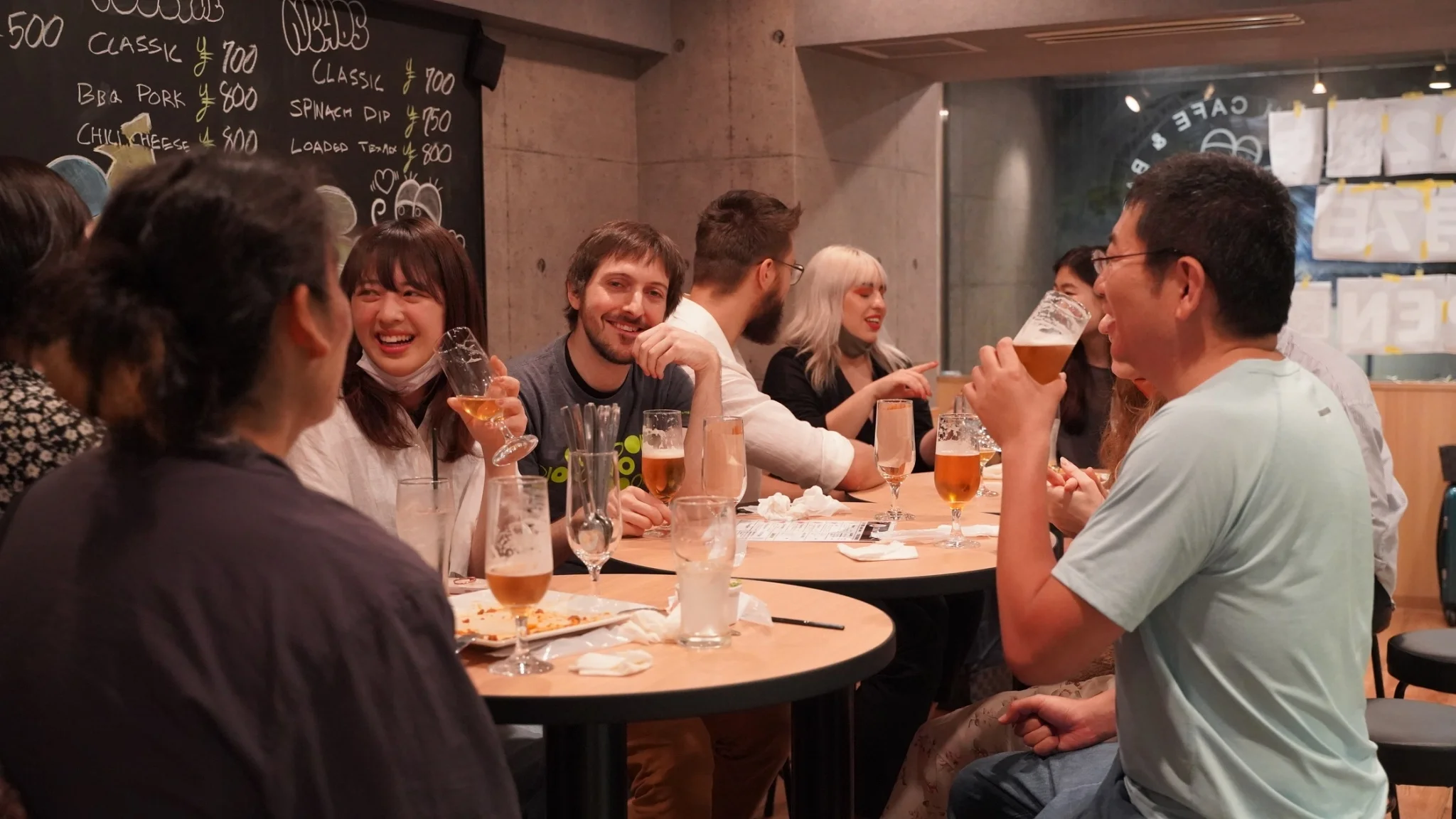 People chatting and drinking around tables.