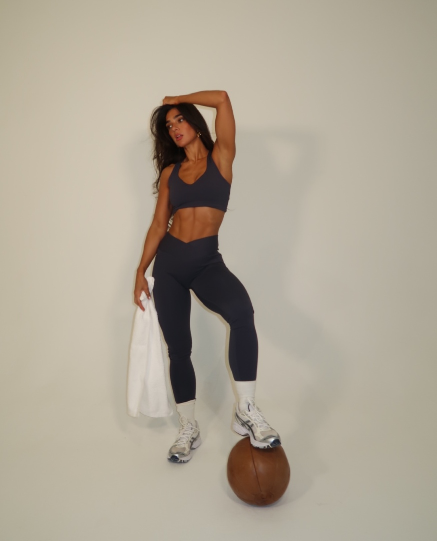 Stef Williams of the WeGLOW workout app for women in gym gear with barbell