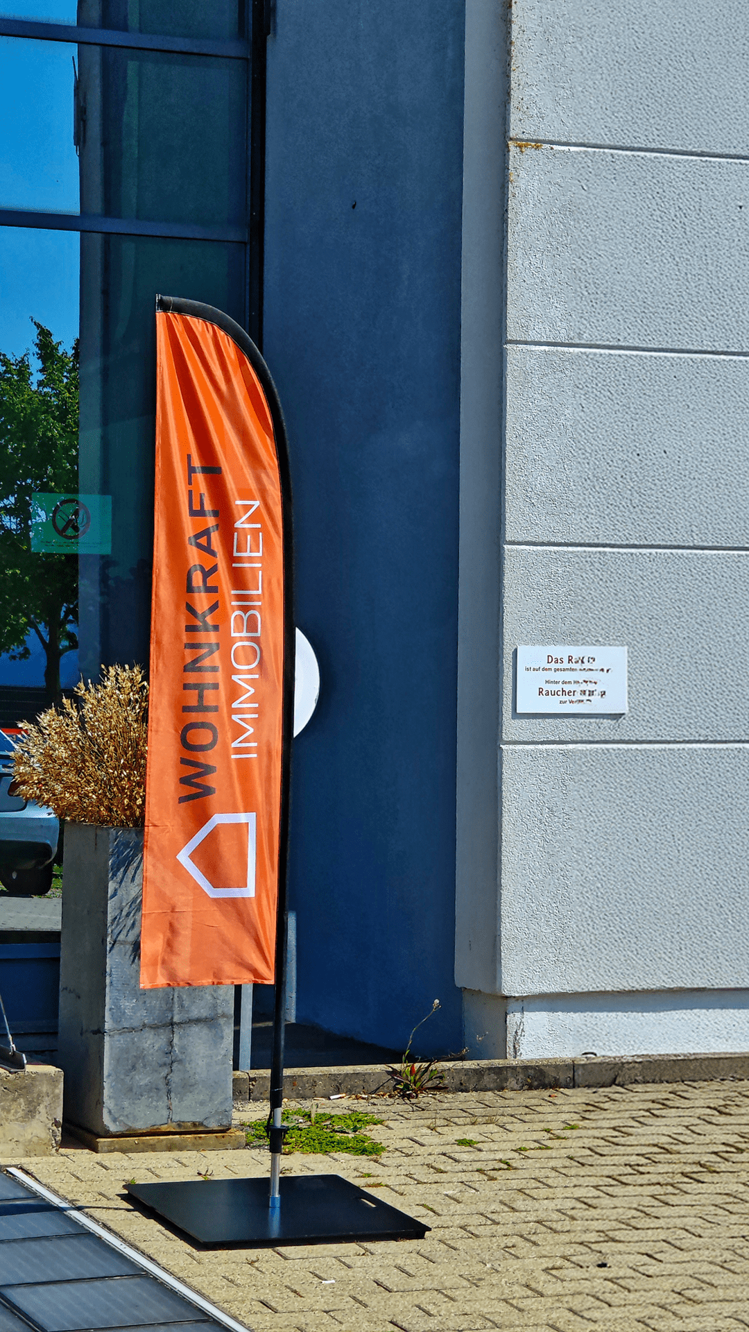 Wohnkraft Immobilien Beachflag vor Gebäudeeingang