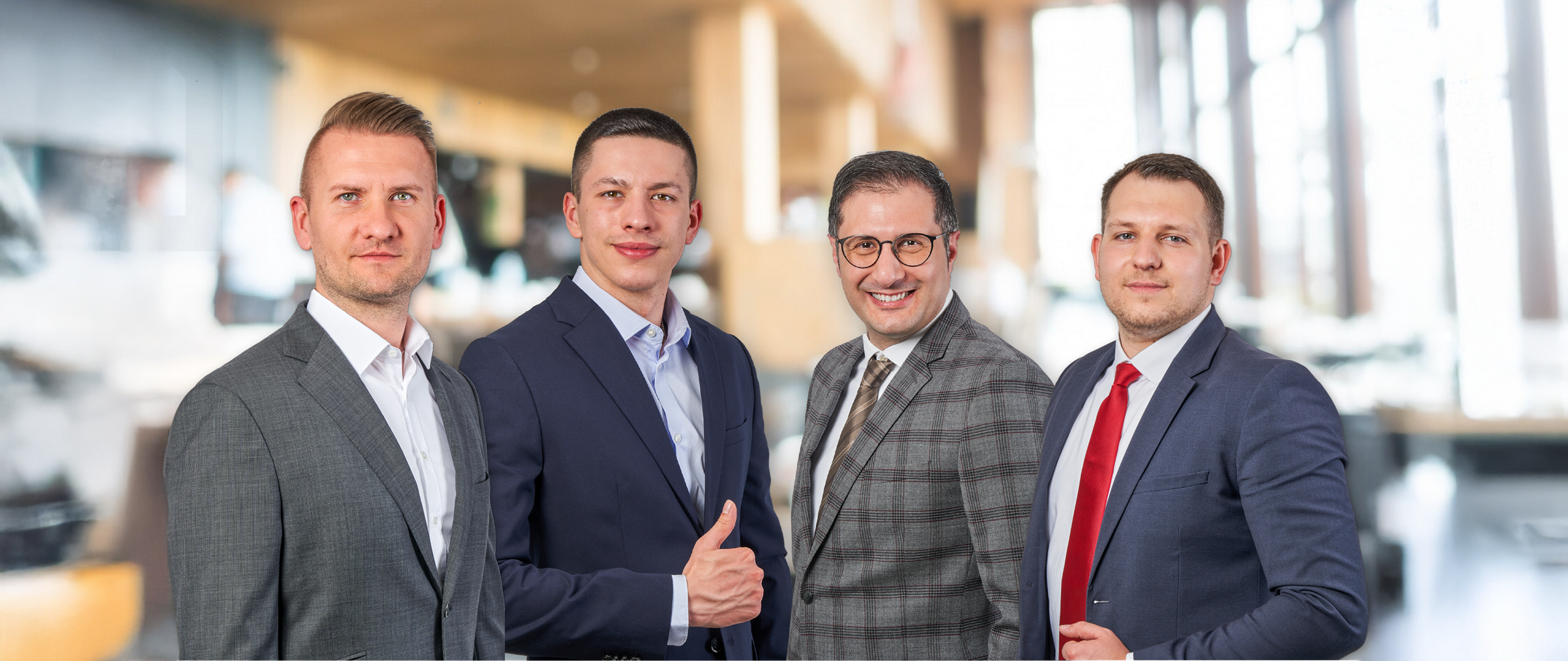 Teambild mit vier Immobilienmaklern im Anzug