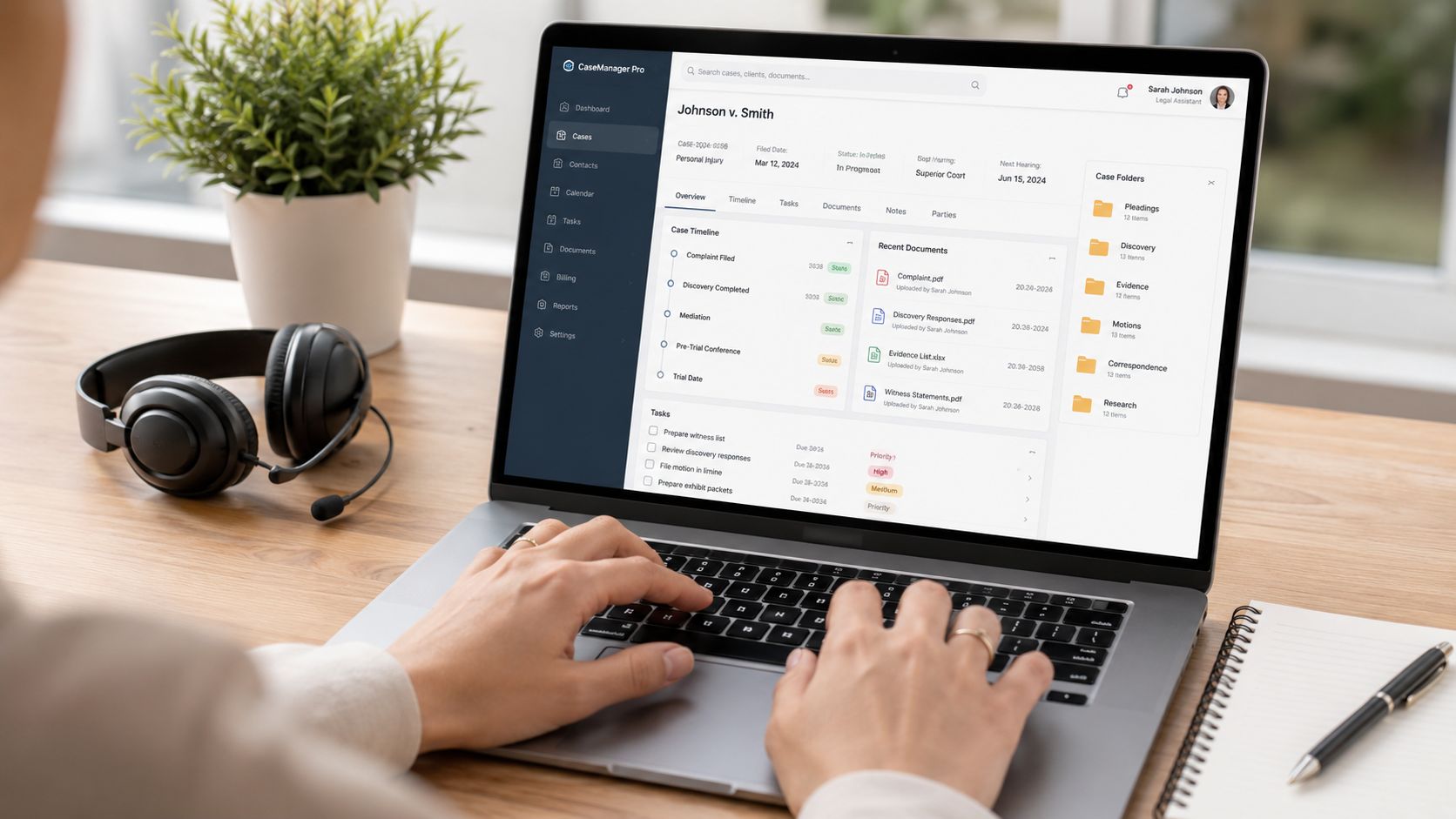 Legal assistant working in case management software on a laptop.