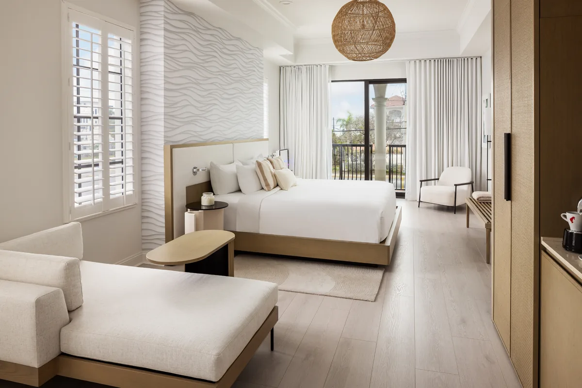 Bright Hotel Zamora guest room with a white bed and neutral decor