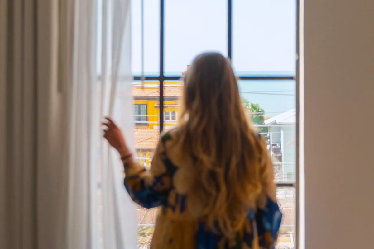 Woman looking out a guest room window
