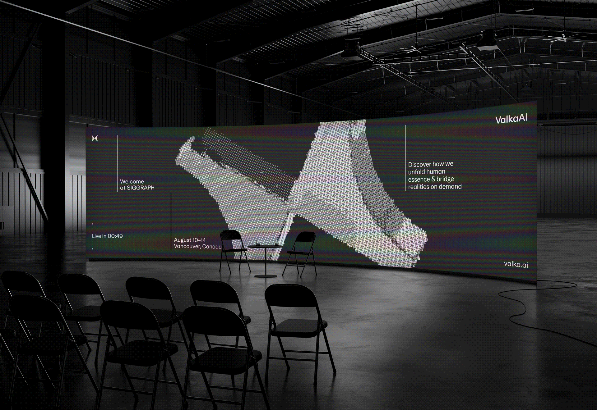 Curved digital screen in a large dark room displaying abstract 3D voxel art and text about Valka AI at SIGGRAPH event in Vancouver, with empty chairs and two chairs with a small table in front.
