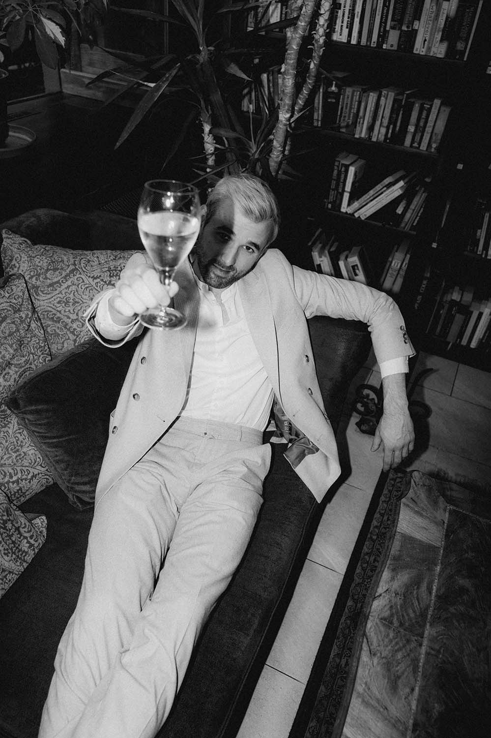 Leo Poldau mit Weinglas in der Hand in einem Cafe