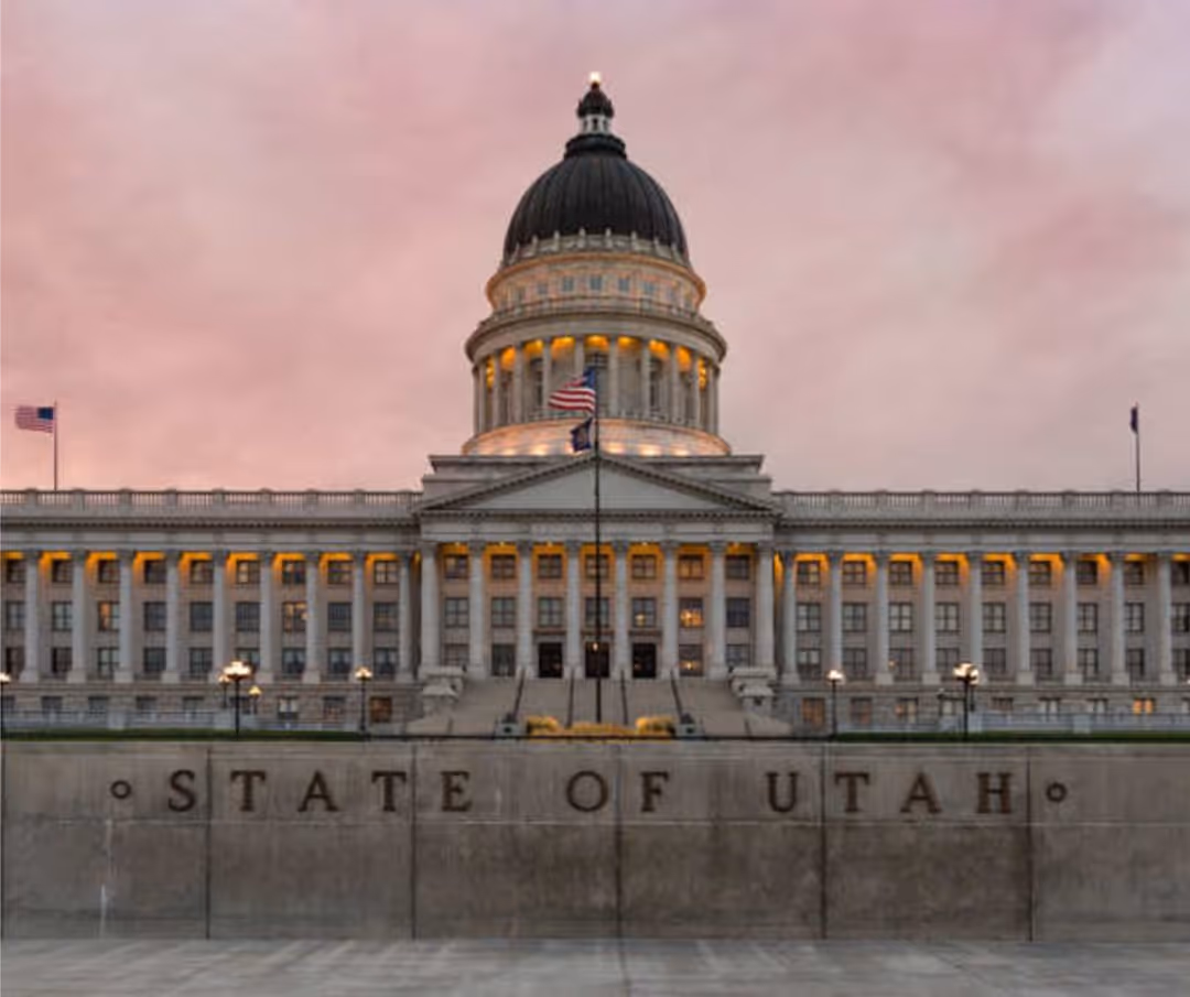A large white building with a statue of a man and a flag.