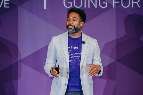 A man in a suit and tie is giving a presentation.