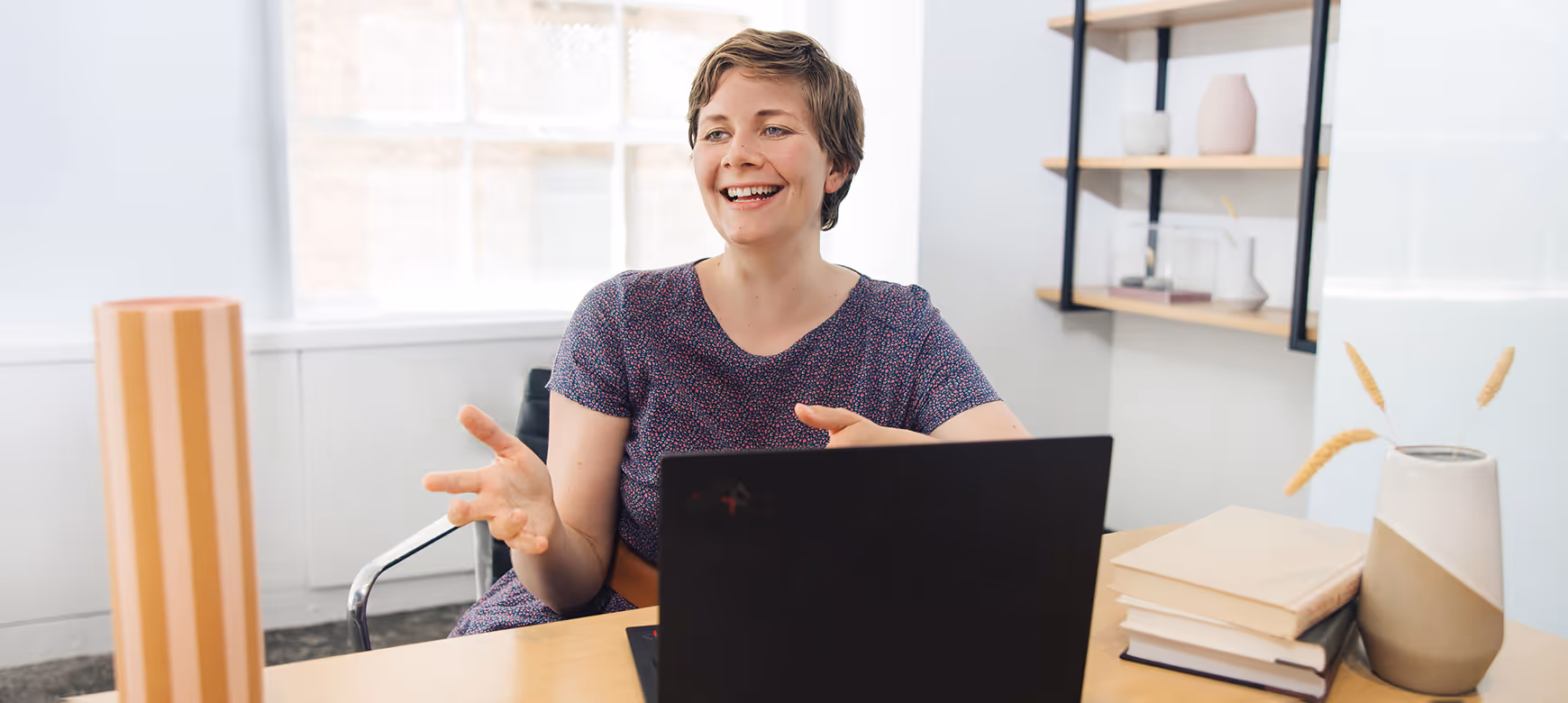 A woman sitting at a desk with a laptop.