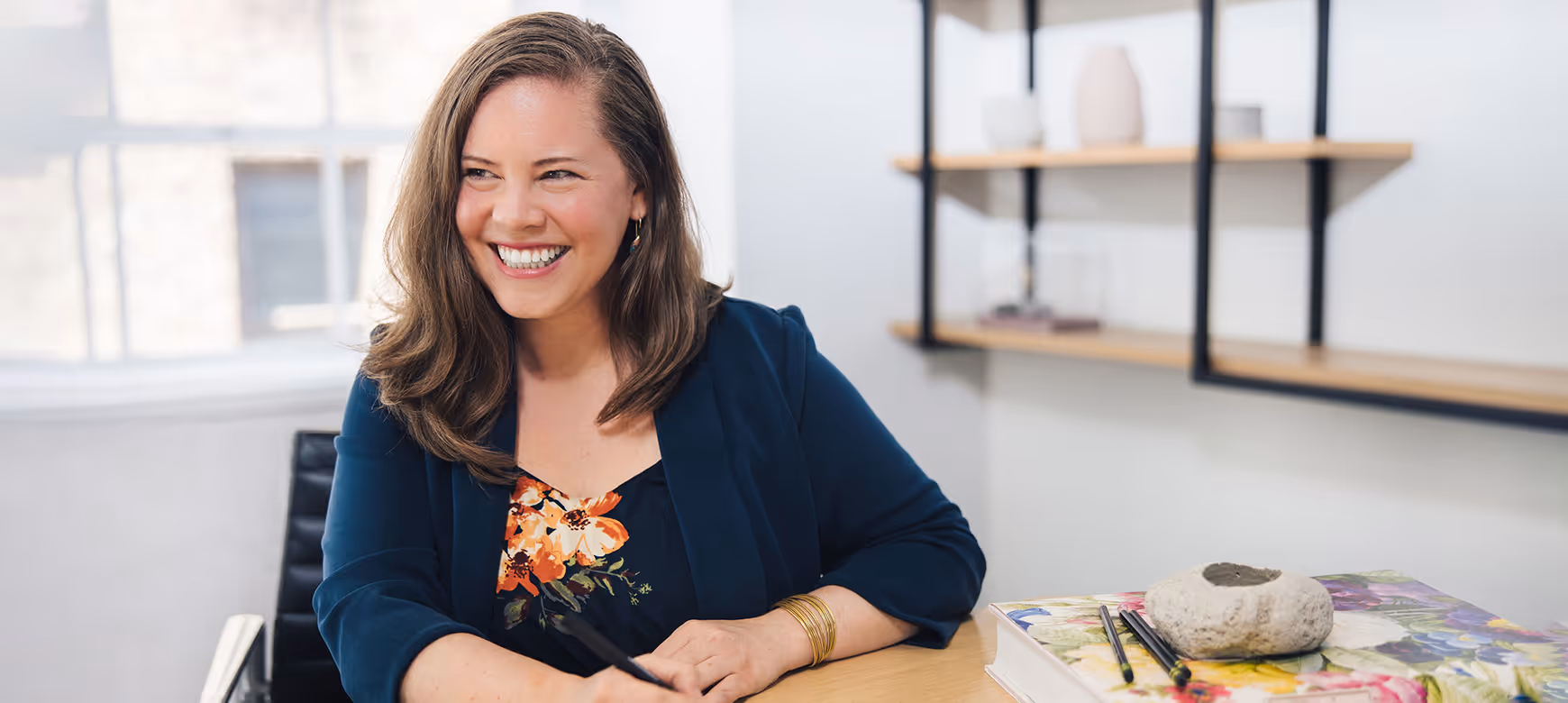 A woman wearing a blue shirt and gold bracelet.