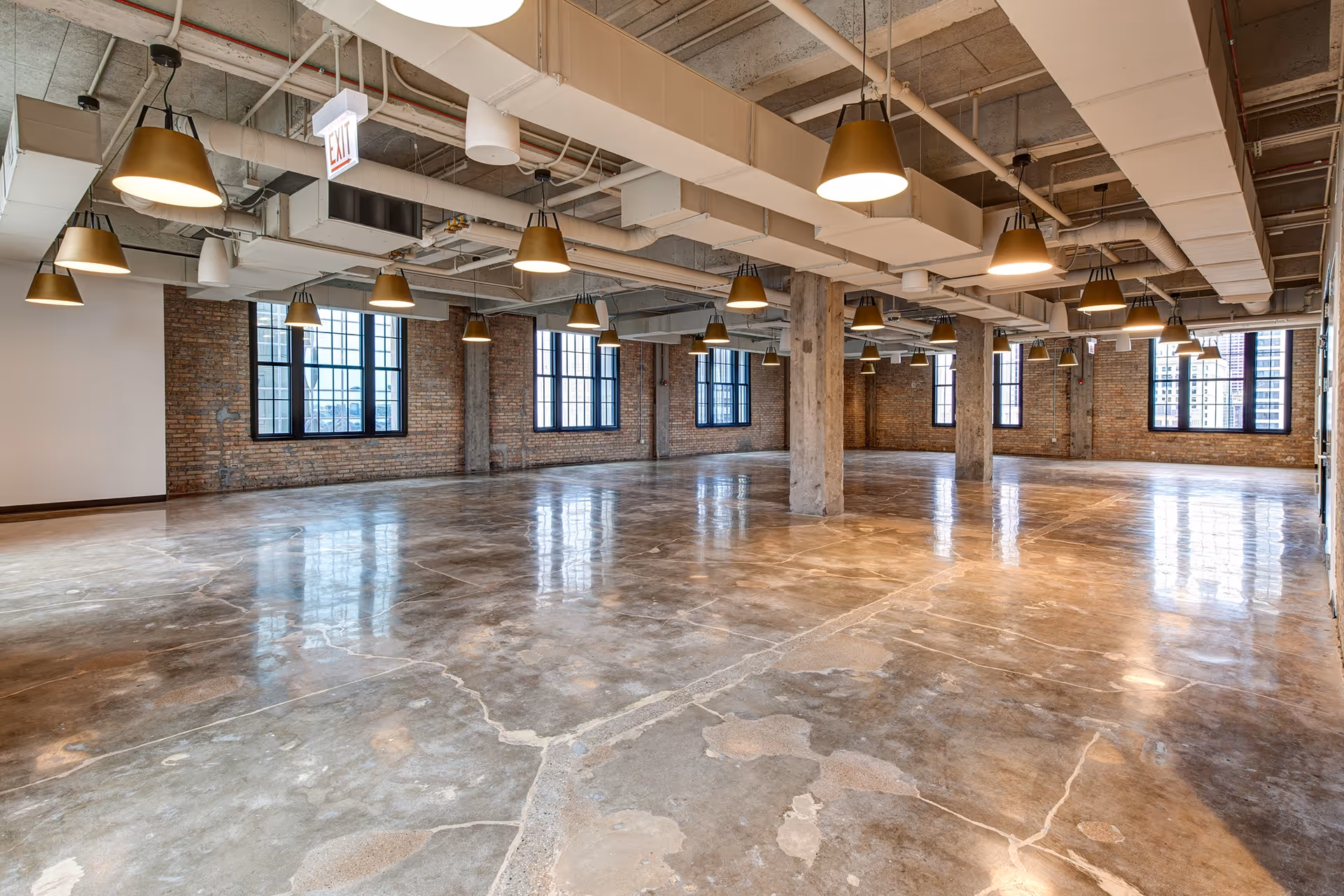 A large open room with a concrete floor and a row of lights.
