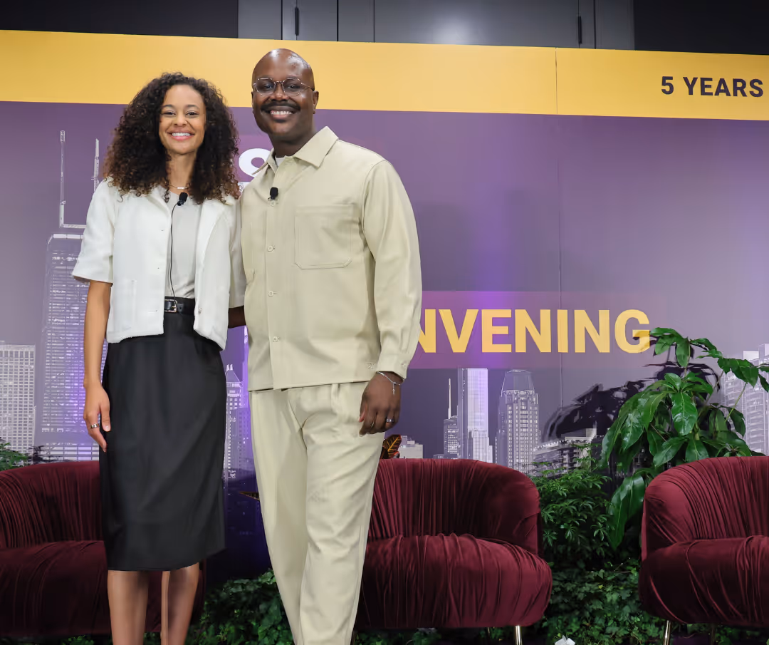 A man and woman stand in front of a sign that says "5 year anniversary".