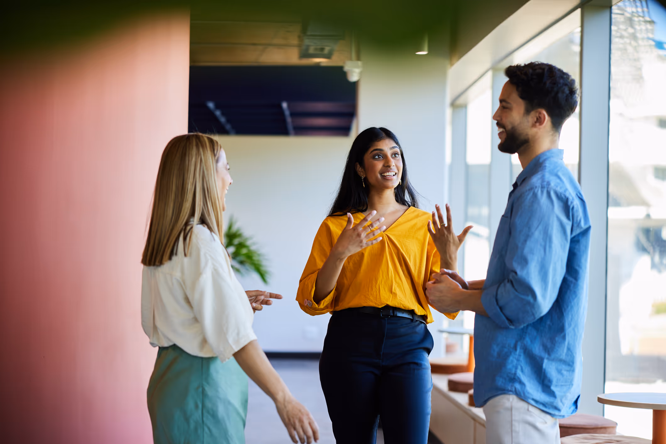 a group of people in a meeting with a man presenting a chart on a board