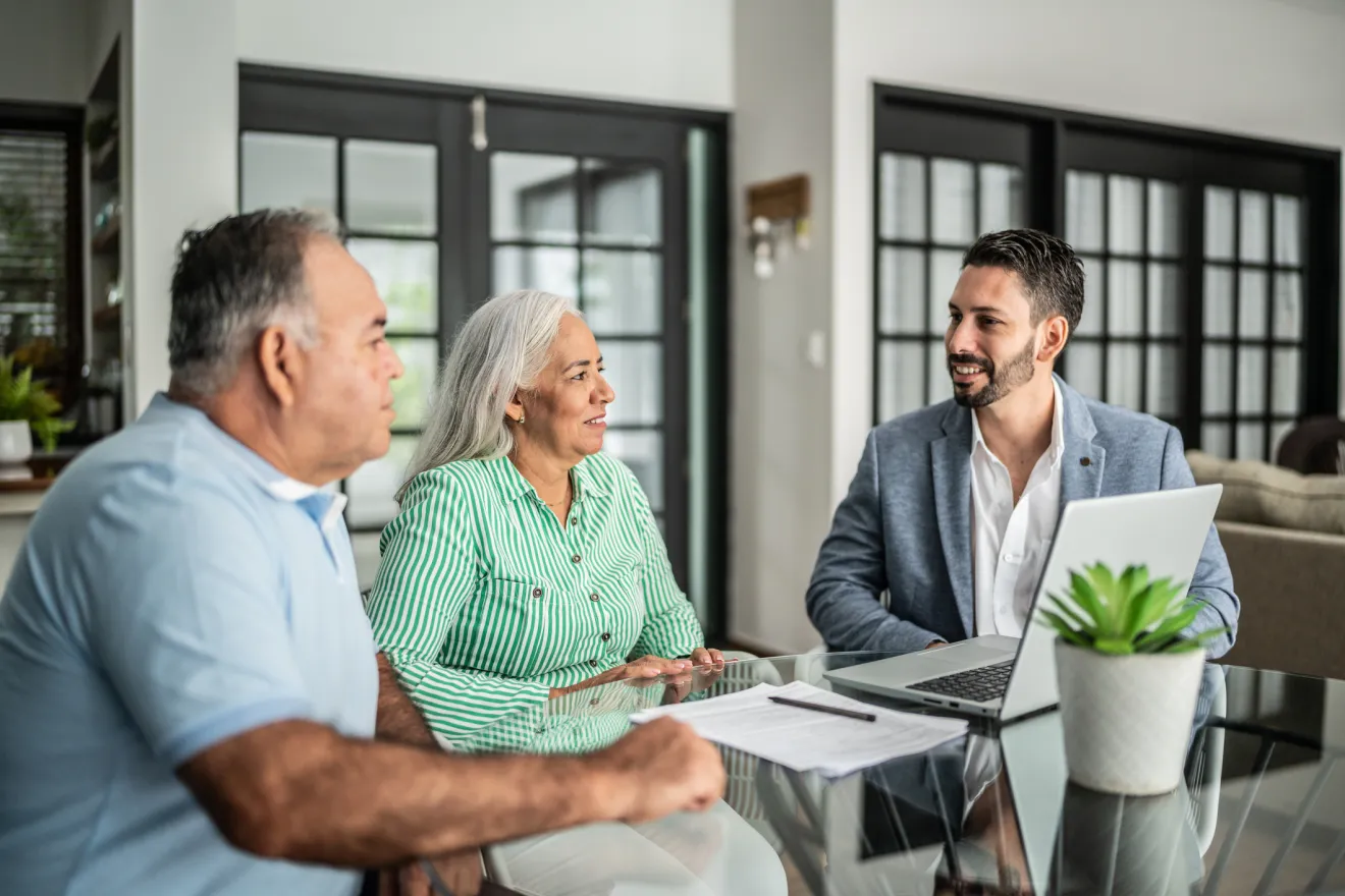 An advisor meeting with an elderly couple in an office setting