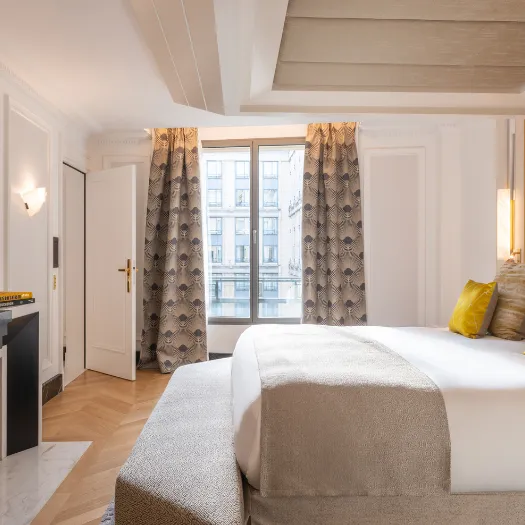 Chambre luxueuse offrant un confort absolu, avec mobilier sophistiqué et ambiance chaleureuse à l’Hôtel du Collectionneur.