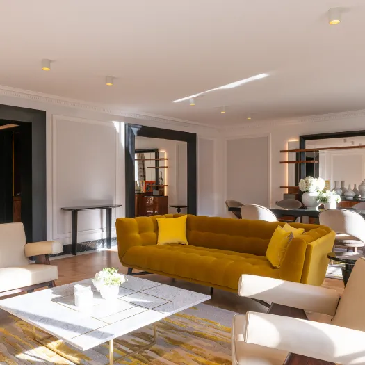 Salon lumineux offrant un cadre chaleureux et luxueux pour un moment de détente à l’Hôtel du Collectionneur.