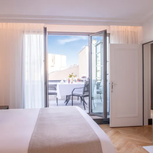 Chambre élégante et spacieuse de l’Hôtel du Collectionneur à Paris, avec lit king-size et décoration raffinée.