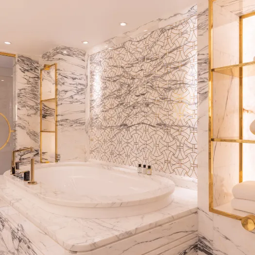 Salle de bain élégante avec marbre raffiné et baignoire spacieuse à l’Hôtel du Collectionneur.