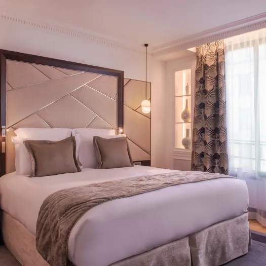 Décoration raffinée et ambiance chaleureuse dans une chambre luxueuse de l’Hôtel du Collectionneur.