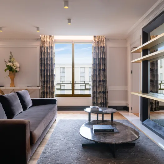 Intérieur raffiné d’une chambre de l’Hôtel du Collectionneur, offrant une atmosphère cosy et prestigieuse.