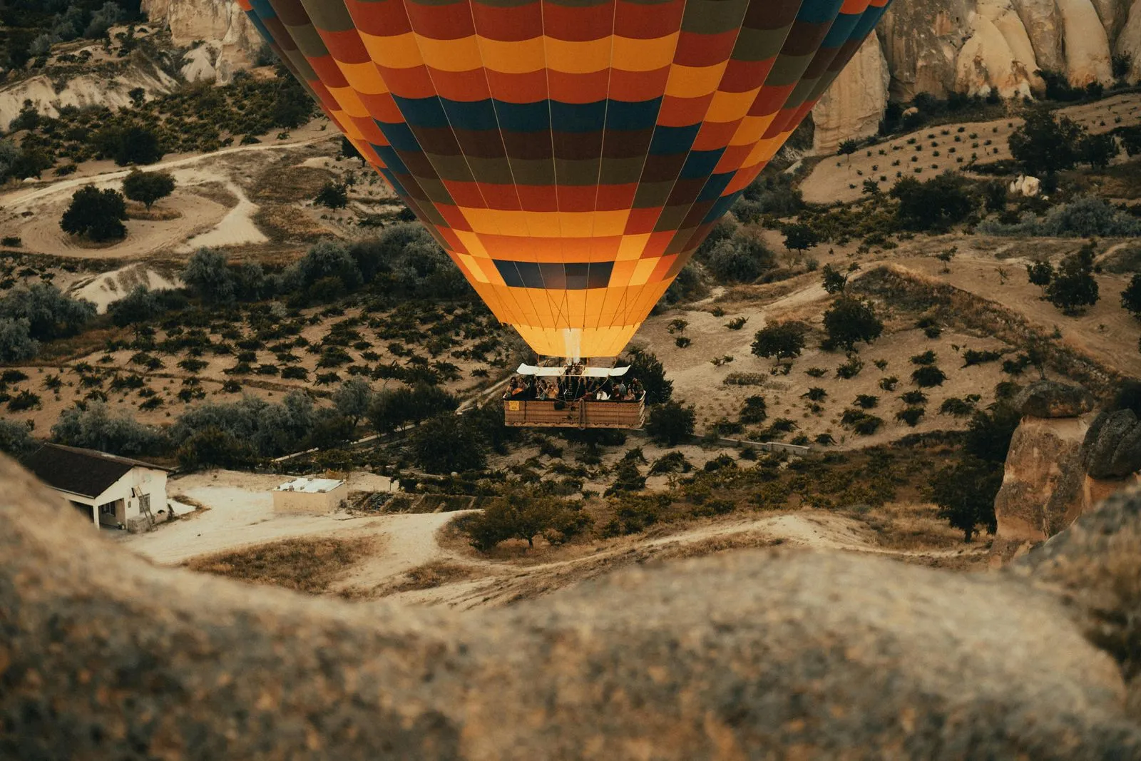 A hot air balloon flying over a valley.