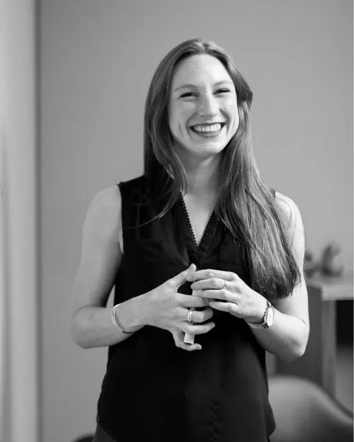 Women smiling next to whiteboard