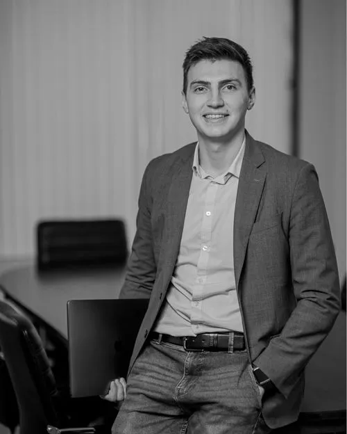 Man sitting on table with laptop by his side