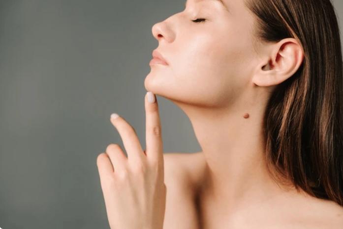 Femme de profil, doigt posé sous le menton, soulignant l'angle entre le cou et le menton