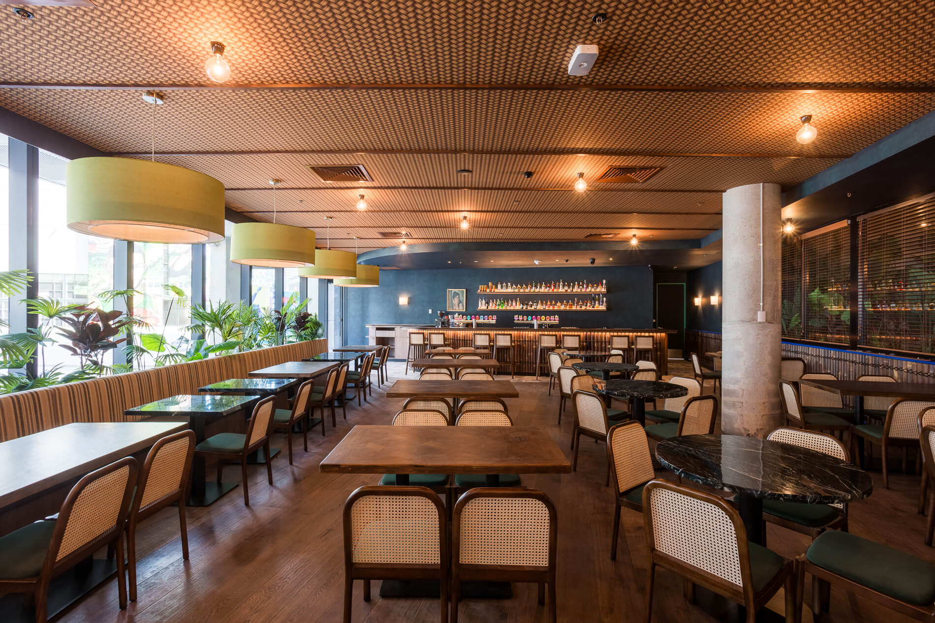 Dining Tables Chairs Large Round Pendant Lights Unique Pattern Ceiling Bar in the Back in Moon Dog Doglands. Photo by Ari Hatzis.