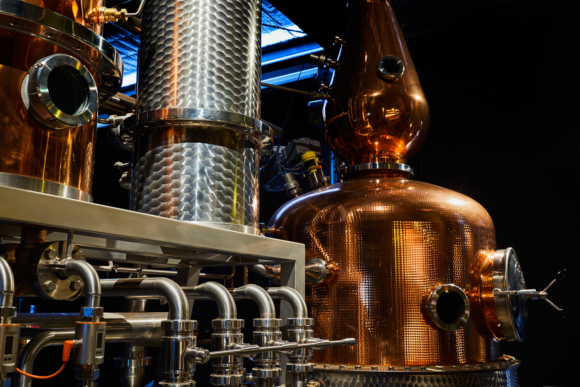Hammered Copper Pot Still Dimpled Stainless Steel Column Industrial Pipework Chrome Valves Detail in Naught Distilling. Photo by Graham Denholm.