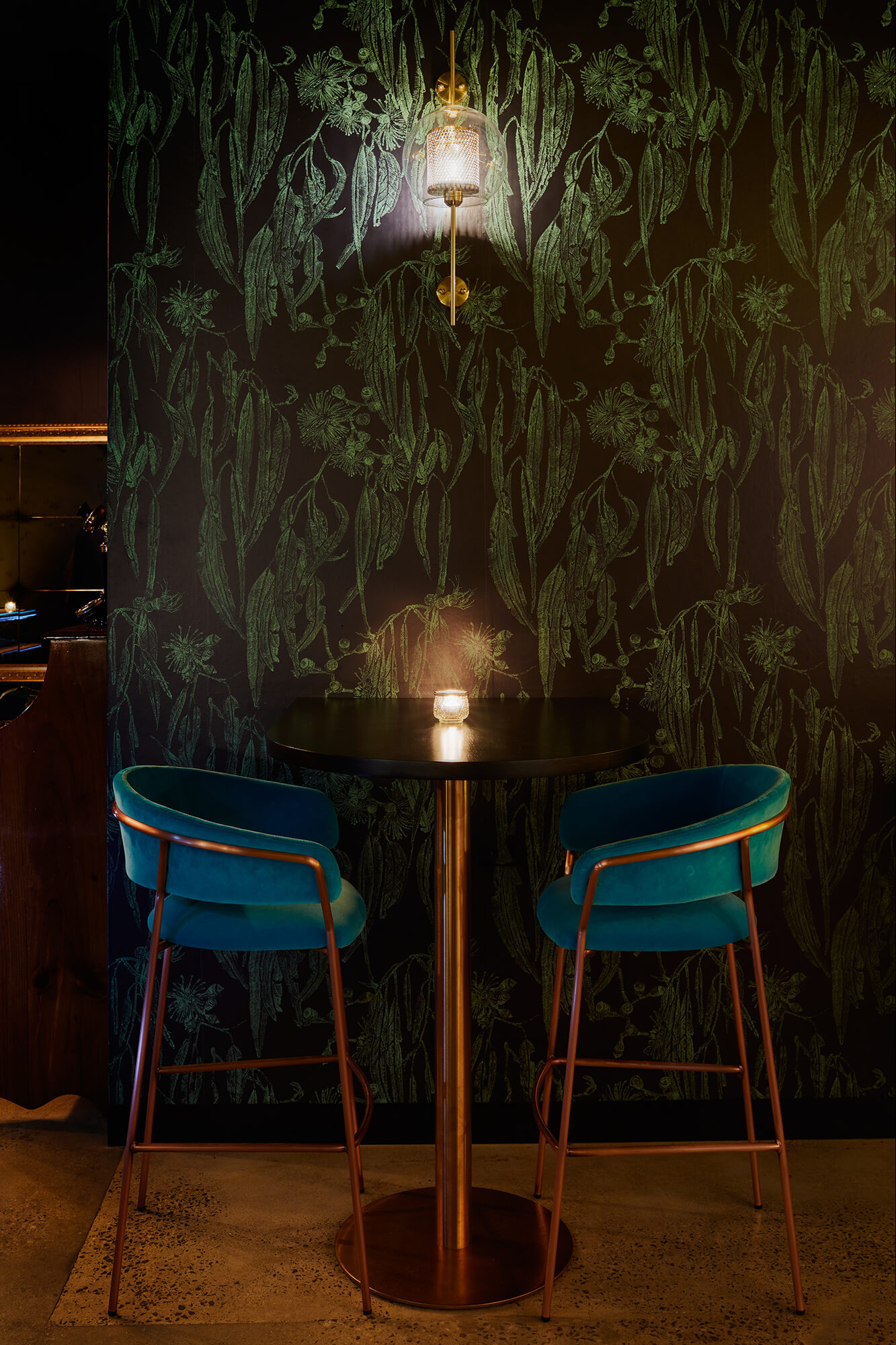 Teal Velvet High Stools Copper Frames Dark Botanical Wallpaper Glass Orb Wall Sconce Black Cafe Table in Naught Distilling. Photo by Graham Denholm.