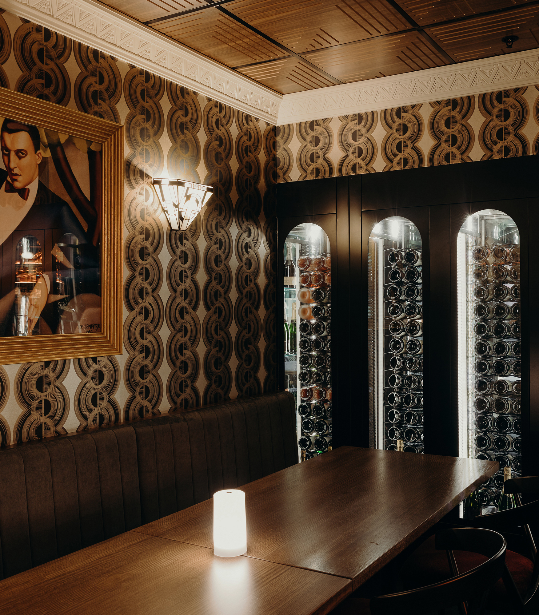 Graphic Wallpaper Arched Wine Cabinets Timber Panelled Ceiling Ornate Cornice Art Deco Fan Sconce Seating in Nick & Nora’s. Photo by Ryan Sauer.