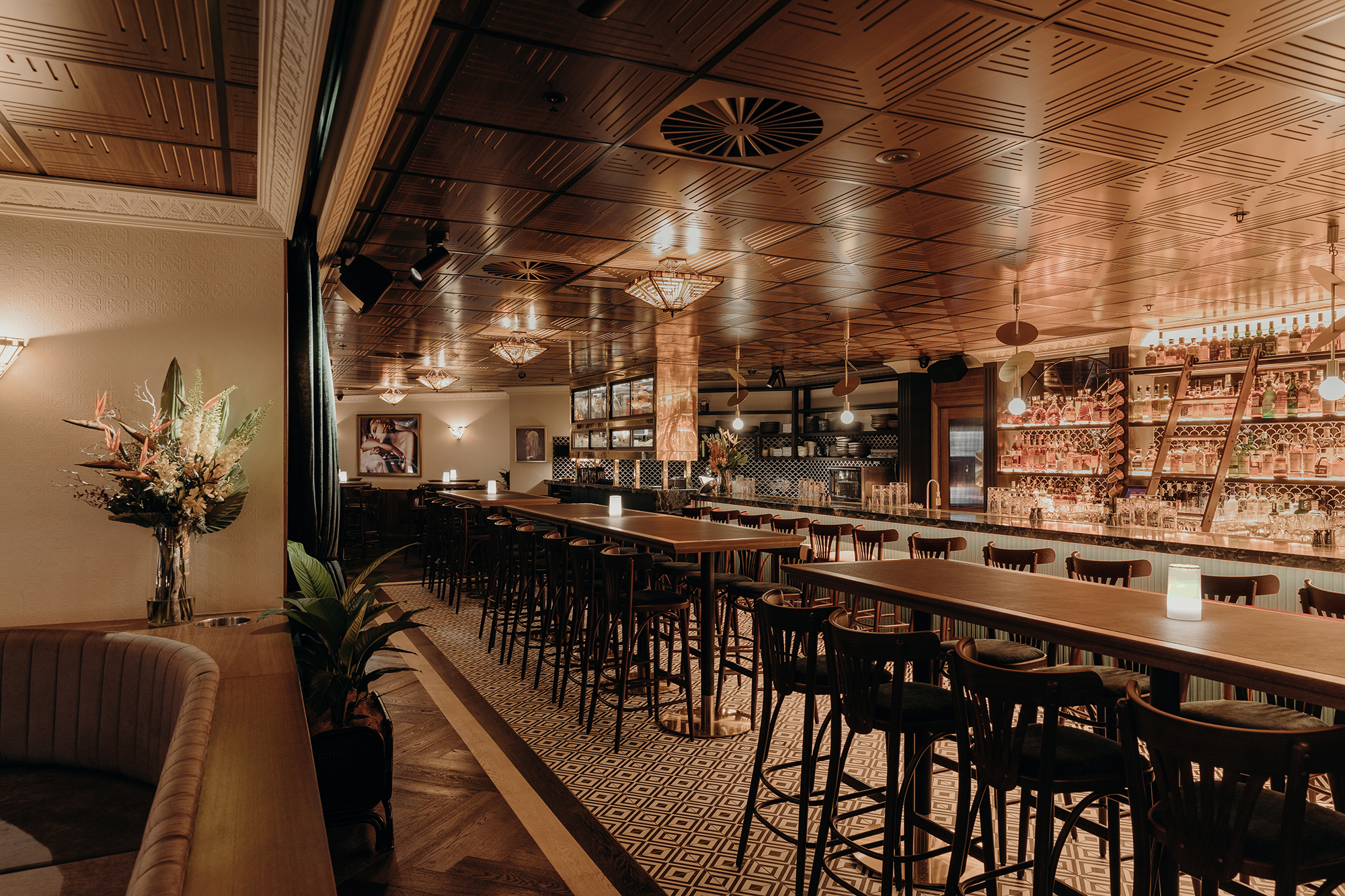 Geometric Timber Ceiling Art Deco Pendants Long High Tables Bentwood Stools Patterned Monochrome Tile Floor in Nick & Nora’s. Photo by Ryan Sauer.