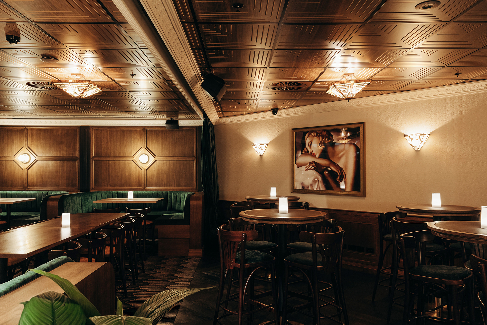 Timber Wall Panelling Circular Brass Sconces Green Velvet Booths High Cafe Tables Framed Portrait Art Geometric Ceiling in Nick & Nora’s. Photo by Ryan Sauer.