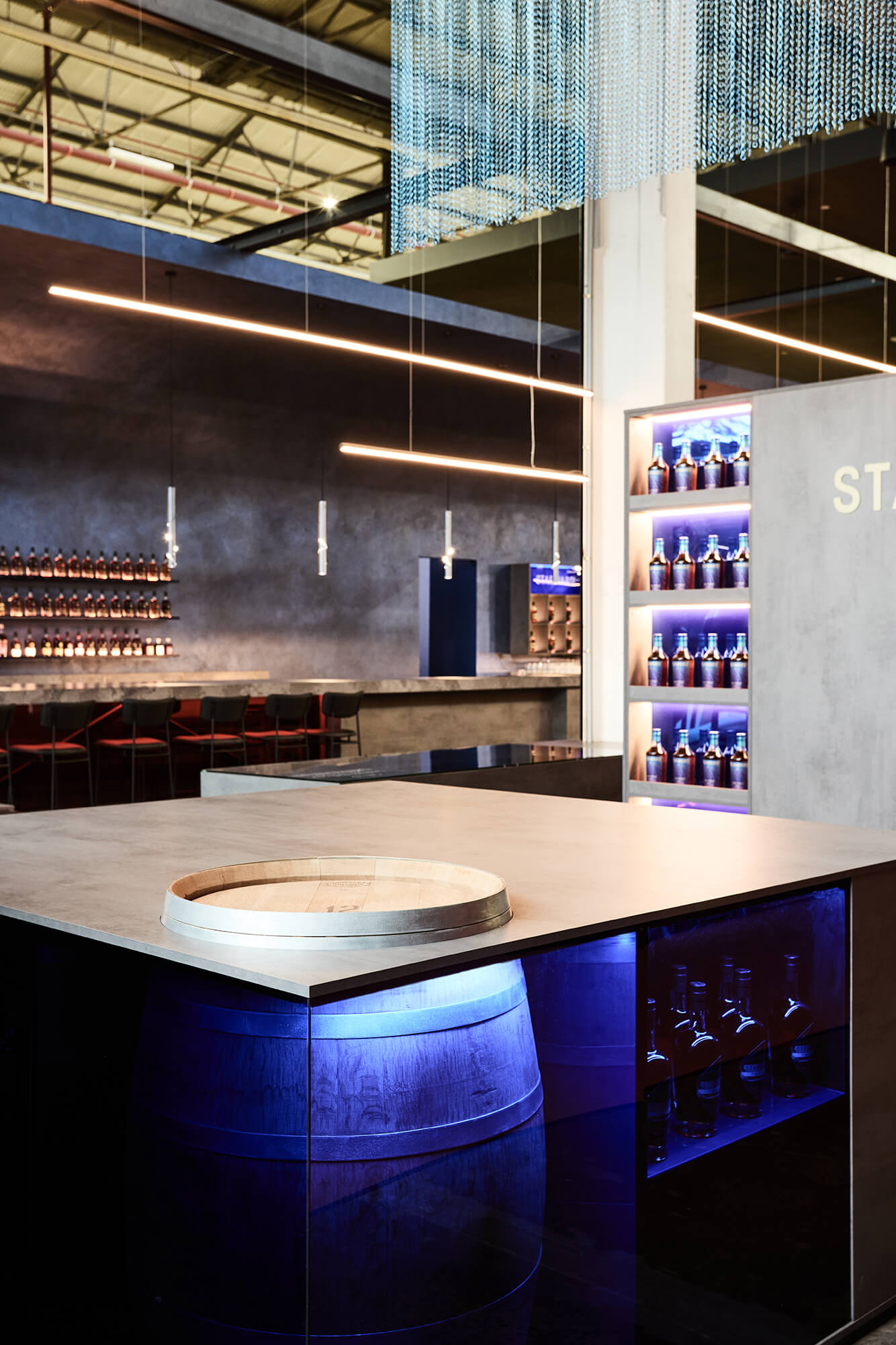 Inset Oak Barrel Blue LED Underlighting Concrete Benchtop Linear Pendant Lights Chainmail Ceiling Installation Dark Rendered Walls in Starward. Photo by James Geer.