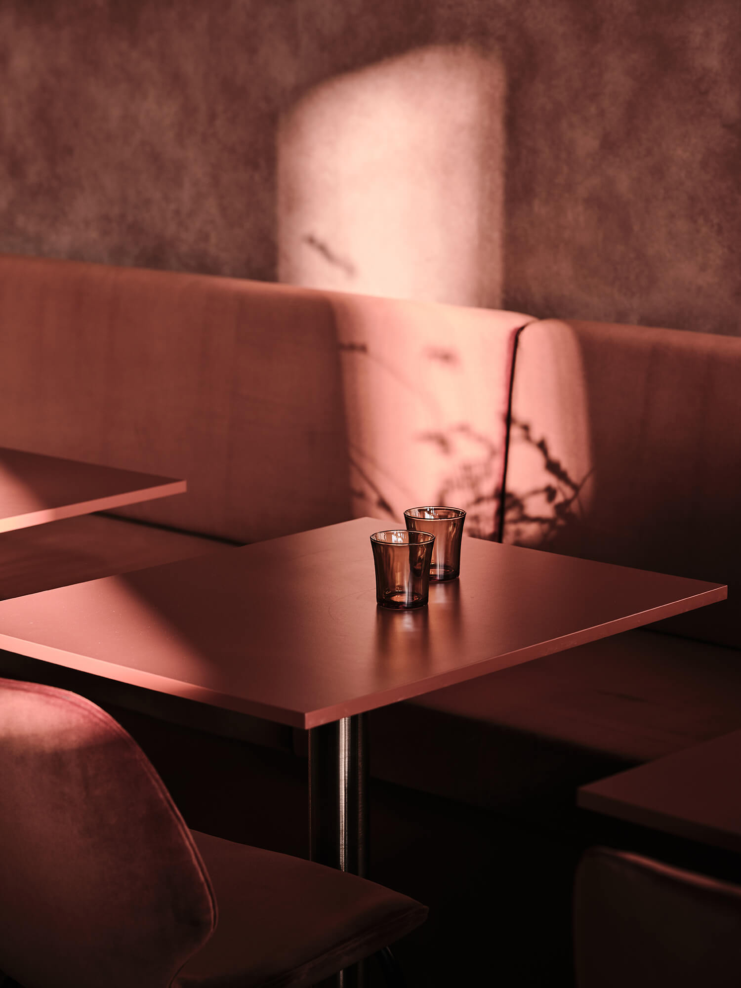 Plum Velvet Banquette Terracotta Toned Cafe Tables Moody Dappled Lighting Textured Earthy Wall Finish Sophisticated Lounge Atmosphere in Starward. Photo by James Geer.