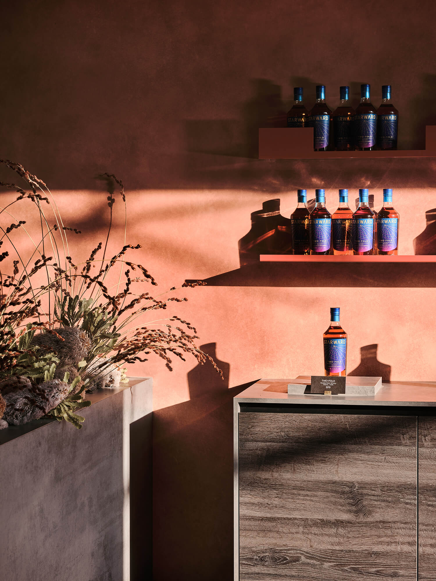 Timber Veneer Cabinetry Slim Floating Shelves Terracotta Stucco Wall Finish Dramatic Sunlight Shadows Native Flora Arrangement in Starward. Photo by James Geer.