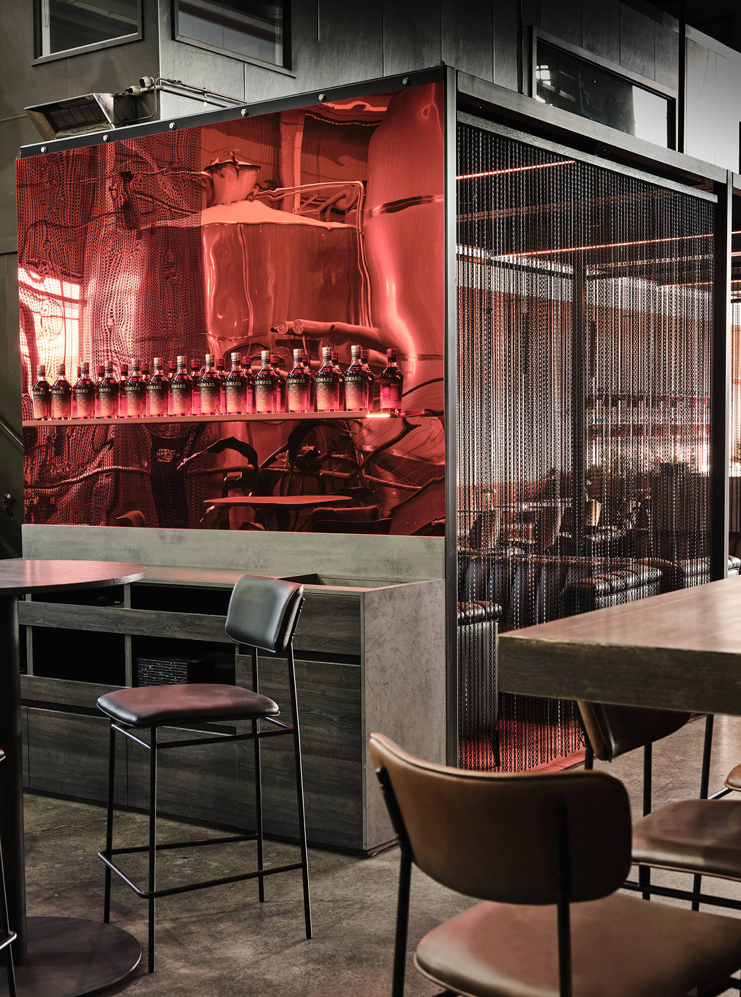 Crimson Mirrored Feature Wall Metal Chain Curtains Black Leather Bar Stools Industrial Steel Framework Raw Distillery Textures in Starward. Photo by James Geer.
