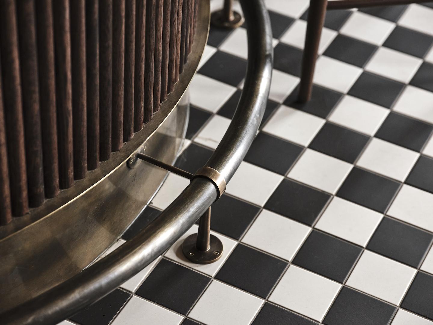 Patinated Metal Bar Base Support Fluted Dark Wood Facing Monochrome Tiled Flooring Heritage Interior Textures and Finishes in The Bay Hotel. Photo by James Geer.