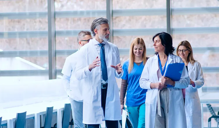 Medical team standing confidently near window

