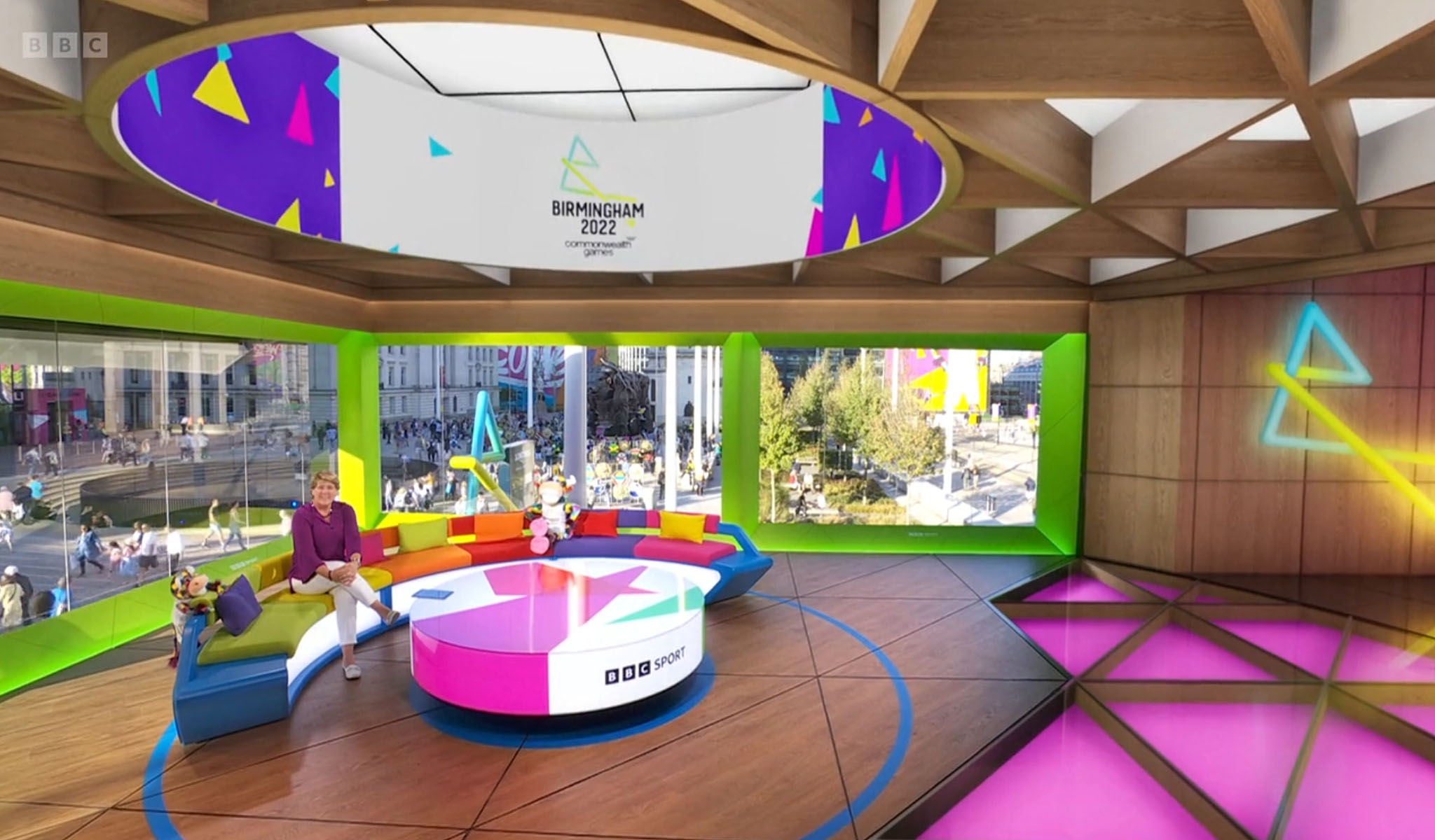 Colorful BBC Sport studio set with a curved couch, circular table, and Birmingham 2022 Commonwealth Games logo.