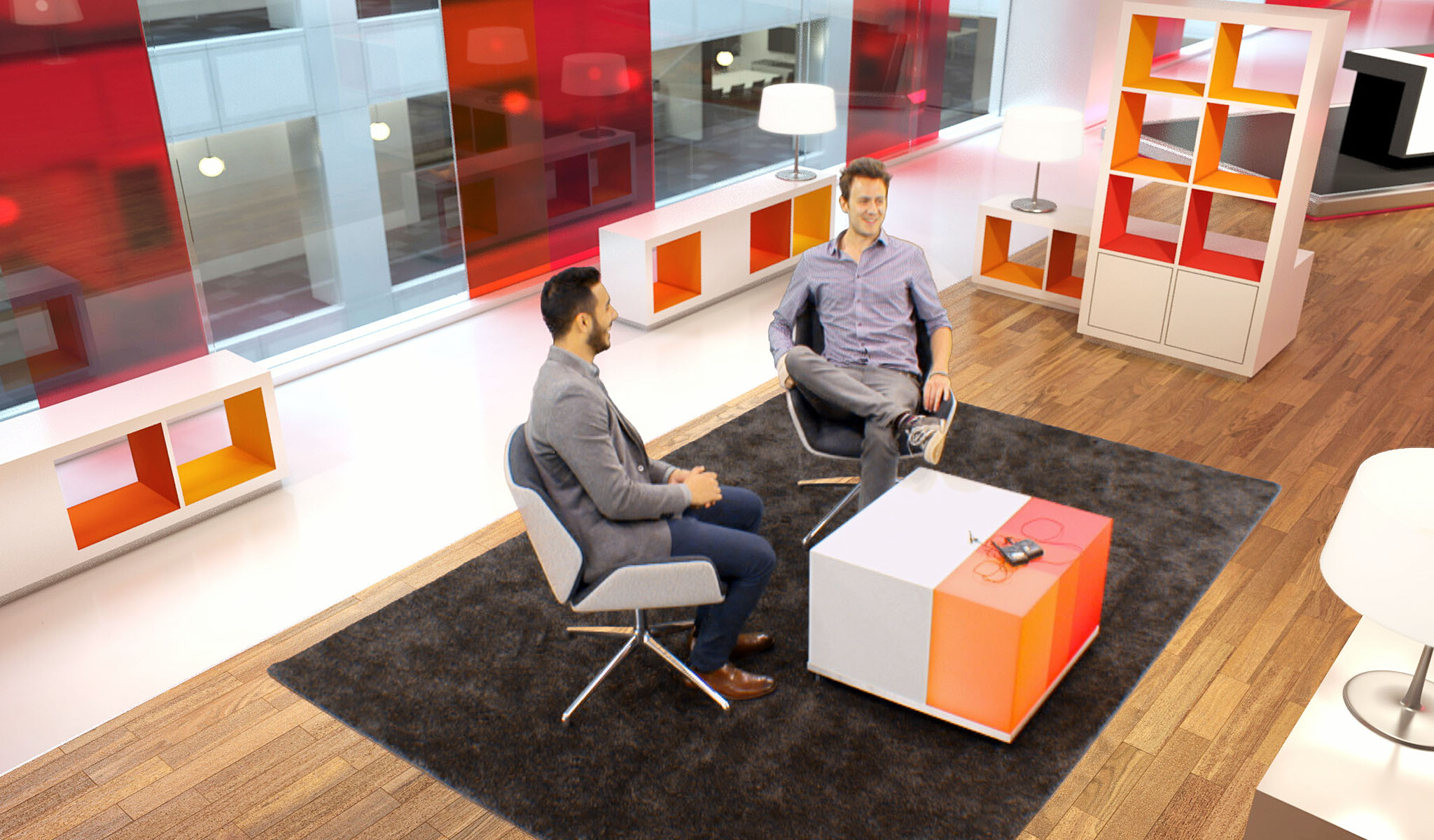 Two men sitting in modern chairs having a conversation in a bright, colorful office lounge area.