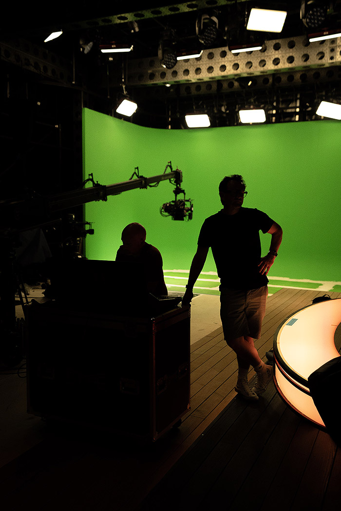 A moment of reflection, on set during testing. The crew are silhoutted against the brightly lit greenscreen area.