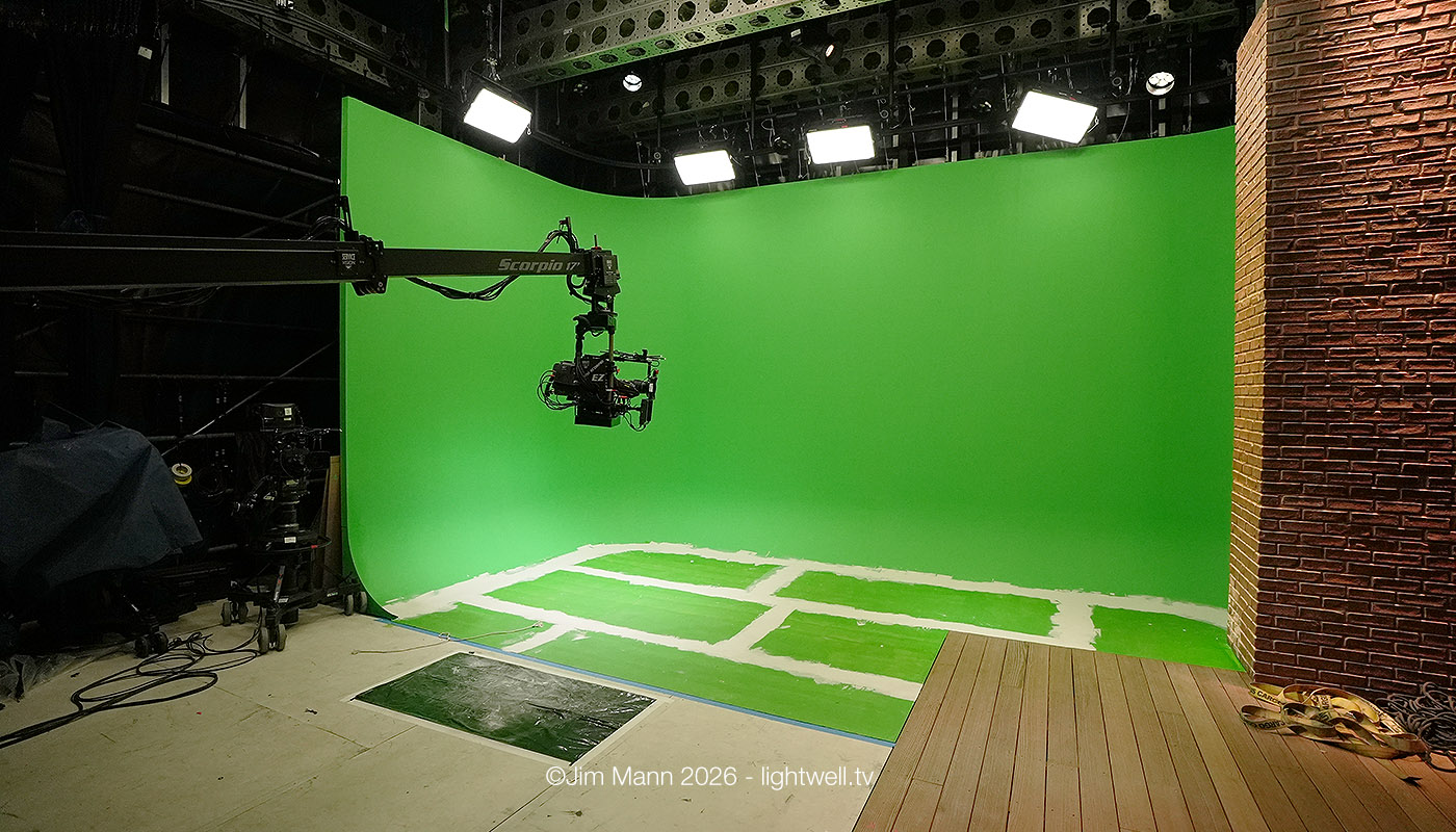 The green screen area within the ITV World Cup studio being prepared for final painting. we see white joint filler contrasting with the vivid green. The technocane has extended into shot, with the camera suspended above at eye level.